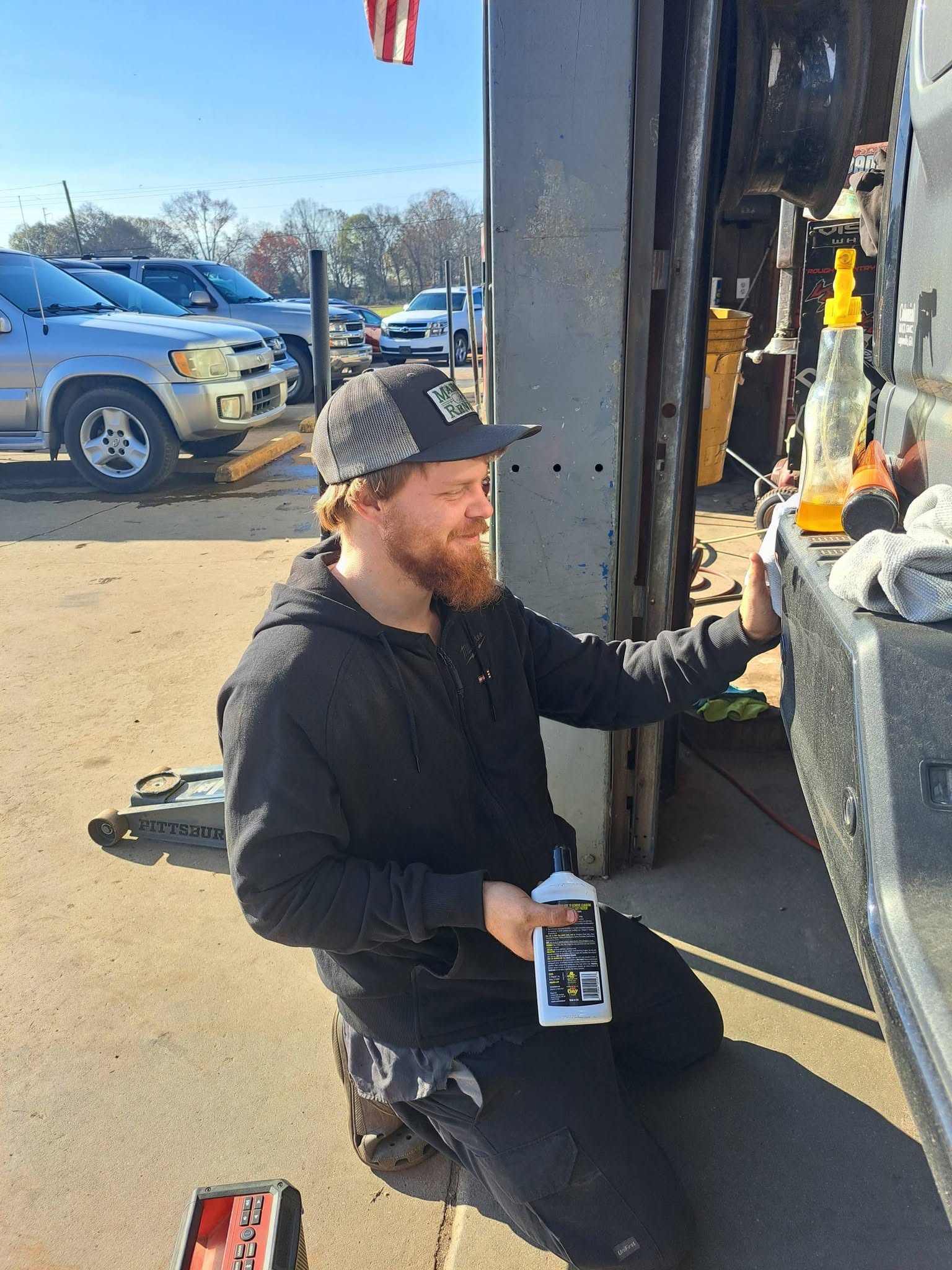 A Madison Car Care technician working beside an open service bay